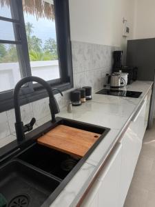 a kitchen sink with a wooden cutting board in it at Villa l'Aurora in Amphoe Koh Samui +8 photos