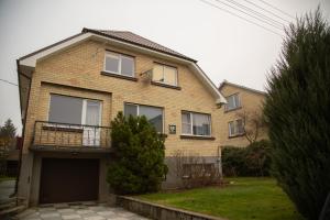 a brick house with a balcony and a garage at Azimut in Šiauliai