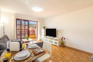 a living room with a table and a television at Apartment in Los Cristianos WIFI in Arona
