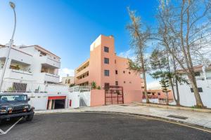 a car parked in a parking lot in front of a building at Apartment in Los Cristianos WIFI in Arona