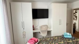 a bedroom with a bed and a tv and white cabinets at Full City Apartment in Bitburg