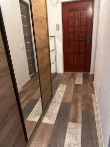 a hallway with a mirror and a wooden door at Medusa Gold Studio in Târgu-Mureş +4 photos