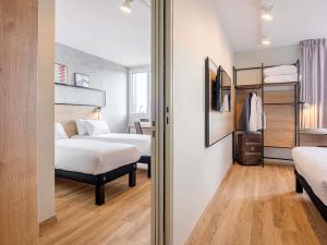 a hotel room with two beds and a closet at ibis Dijon Sud in Perrigny-lès-Dijon +23 photos