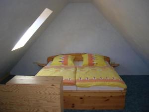 a bed with yellow and orange pillows in a room at Freistehendes Ferienhaus In Ruhiger Lage in Rubitz