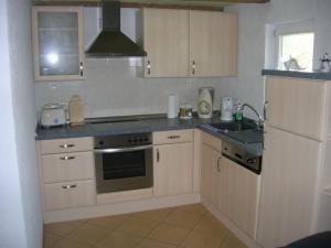 a kitchen with white cabinets and a stove top oven at Freistehendes Ferienhaus In Ruhiger Lage in Rubitz