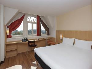 a hotel room with a bed and a desk and window at ibis Metz Centre Gare in Metz