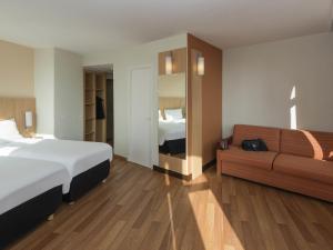 a hotel room with a bed and a couch at ibis Metz Centre Gare in Metz +29 photos