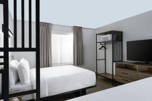 a bedroom with a bed and a flat screen tv at StudioRes Jacksonville Orange Park in Jacksonville