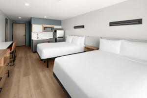 a hotel room with two beds and a kitchen at StudioRes Jacksonville Orange Park in Jacksonville +2 photos