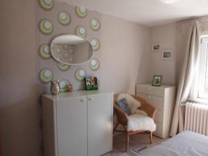 Zimmer mit einem Kühlschrank, einem Stuhl und einem Spiegel in der Unterkunft Apartments Schnepel in Sankt Michaelisdonn