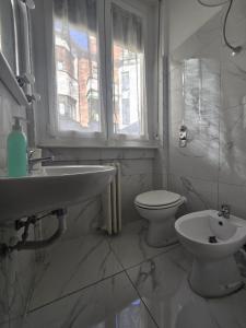 a bathroom with a sink and a toilet and a window at Bilocale 40 mq con parcheggio privato in Milan