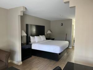 a bedroom with a large white bed and a couch at Texas Inn & Suites Pharr/San Juan in Pharr