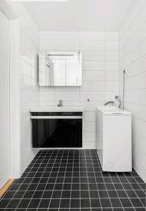 een witte badkamer met een wastafel en een spiegel bij Cottage studio in city centre in Tromsø