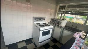 a kitchen with a white stove and a microwave at 33 Boeren in Vryheid +5 photos