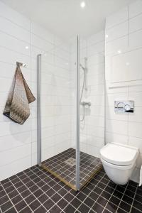 een badkamer met toilet en glazen douche bij Cottage studio in city centre in Tromsø