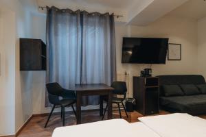 a living room with a table and a couch at Hotel Latio in Cologne