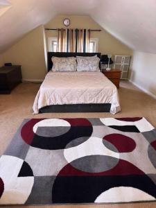 a bedroom with a large bed with a rug on the floor at Natvy Alpha Suite - 3 Bedroom in Munhall
