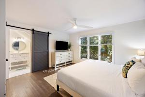 a white bedroom with a bed and a tv at SI2995: 2995 Seabrook Island Rd. in Seabrook Island +44 photos