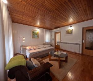 a bedroom with a bed and a couch and a table at Apartma Mika in Most na Soči