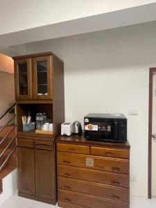 a kitchen with a microwave on top of a dresser at Lazy shot in Ban San Ton Ko (1)