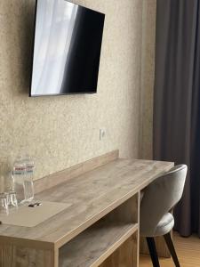 Ein Holztisch mit Stuhl und ein Fernseher an der Wand in der Unterkunft Anturazh Resort in Brody