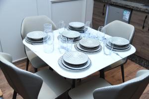a white table with black and white plates and glasses at Suite Bahiya 11 in Fès