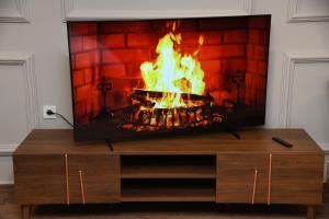 a television with a fire in a fireplace at Suite Bahiya 11 in Fès