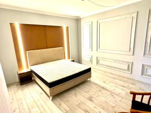 Un dormitorio con una cama y suelo de madera. en Eurasia Turkestan, en Türkistan