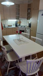 a kitchen with a white table with a vase of flowers on it at Kaksio oma piha ja autoparkki in Savonlinna