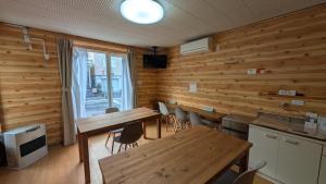 a dining room with wooden walls and tables and chairs at Hakodate Stay Walk to Onsen and History in Hakodate