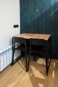 a wooden table with black chairs in a room at Bilyi Slon Gadzhyna in Velykyi Khodak +25 photos