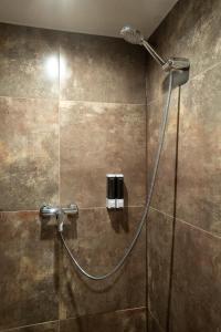a shower with a hose in a bathroom at Bilyi Slon Gadzhyna in Velykyi Khodak