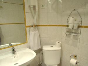 a bathroom with a toilet and a sink and a mirror at Hôtel du Square d'Anvers in Paris
