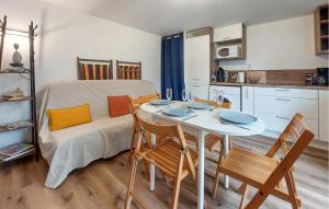ein Wohnzimmer mit Tisch und Stühlen und eine Küche in der Unterkunft Appartement Proche Plage in Royan