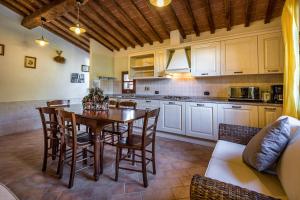 een keuken met een houten tafel en stoelen in een kamer bij Casale Il Chicchero in Castel San Gimignano