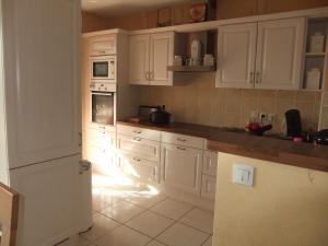 a kitchen with white cabinets and white appliances at Résidence CAP HORIZON in Brive-la-Gaillarde