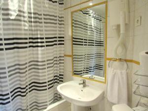 a bathroom with a sink and a shower curtain at Hôtel du Square d'Anvers in Paris