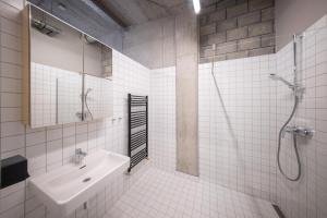 a white bathroom with a sink and a shower at Hotel Aréna in Jihlava