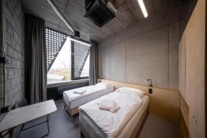 two beds in a small room with a window at Hotel Aréna in Jihlava +7 photos