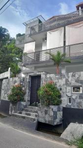 a building with two potted plants in front of it at CrossWay Inn Thalawathugoda in Talawatugoda