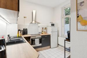 a kitchen with a sink and a refrigerator at Larooms KU11 - Zentrales & charmantes Altbauapartment - All inclusiv! in Halle Saale in Halle an der Saale +12 photos