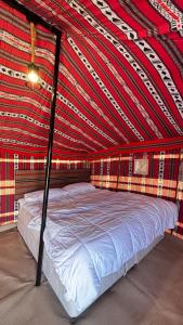 un letto in una stanza con un soffitto rosso e nero di Majicdunes a Al Raka Altre 28 foto