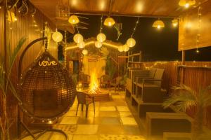 Urban homestay volcastay في Zirakpur: غرفة مع كراسي وأضواء على الفناء