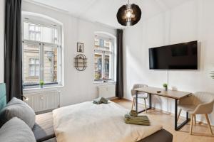 a living room with a bed and a desk at Larooms KU11 - Zentrales & charmantes Altbauapartment - All inclusiv! in Halle Saale in Halle an der Saale