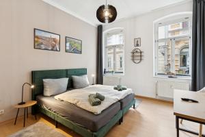 a bedroom with a bed and two windows at Larooms KU11 - Zentrales & charmantes Altbauapartment - All inclusiv! in Halle Saale in Halle an der Saale