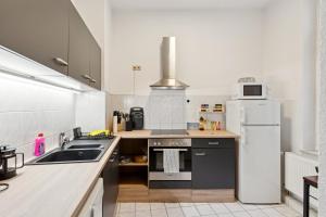 a kitchen with a sink and a refrigerator at Larooms KU11 - Zentrales & charmantes Altbauapartment - All inclusiv! in Halle Saale in Halle an der Saale
