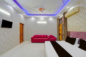 una habitación con una cama y un sofá rojo en Hotel O Laresa, en Ghaziabad 21 fotos más