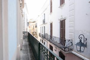 une allée avec des bâtiments blancs et un balcon dans l'établissement Ca La Manso, à Sitges