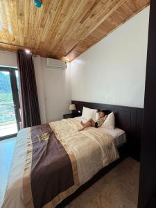 a woman sitting on a bed in a bedroom at Khách sạn Giang Sơn Bắc Hà Lào Cai in Bắc Hà +4 photos