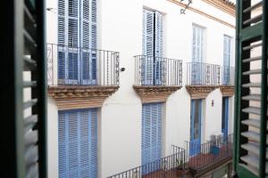 une rangée de balcons sur un immeuble aux volets bleus dans l'établissement Ca La Manso, à Sitges